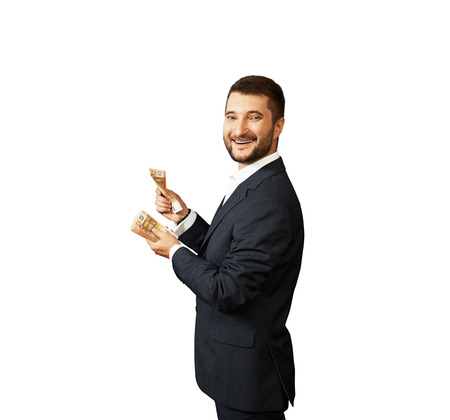 laughing businessman counting money. isolated over white backgroundの写真素材