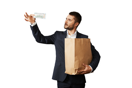 man looking at banknote and holding paper bag. isolated on white backgroundの写真素材