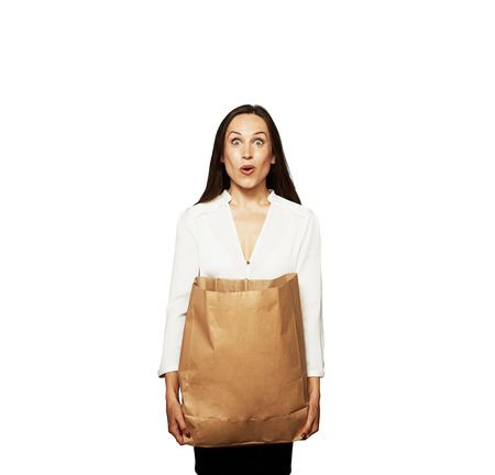 amazed young woman holding paper bag. isolated on white backgroundの写真素材