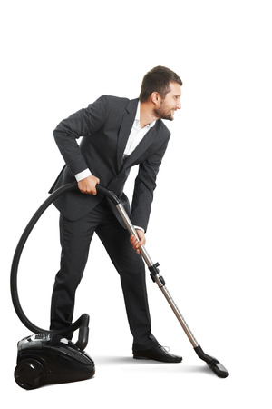 smiley businessman doing vacuum cleaning over white backgroundの写真素材