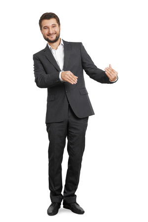 smiley businessman holding something and looking at camera. isolated on white backgroundの写真素材