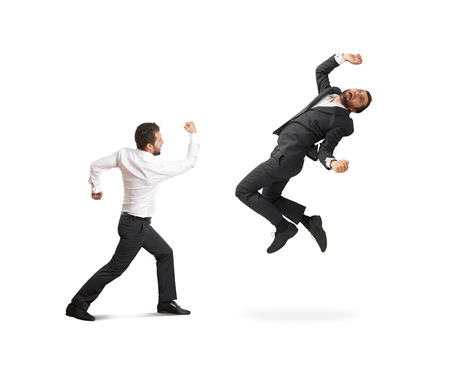 conflict between two businessmen. one businessman in formal wear beating his fist, second man flying and screaming. isolated on white backgroundの写真素材