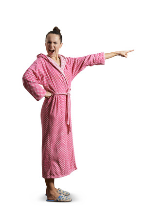 angry screaming woman in pink dressing gown looking at camera and pointing at something. isolated on white backgroundの写真素材