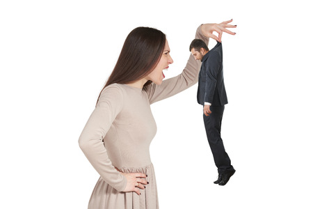 angry woman holding small man and yelling at him. isolated on white backgroundの写真素材