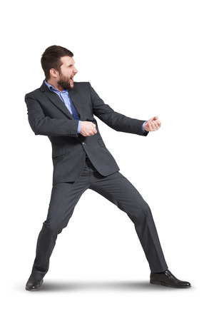 screaming businessman pulling invisible rope. isolated on white backgroundの写真素材