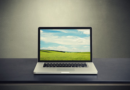 laptop computer with beautiful landscape background on monitorの写真素材