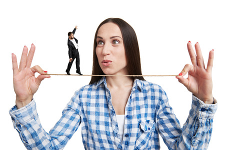 amazed woman looking at small man on the rope. isolated on white backgroundの写真素材