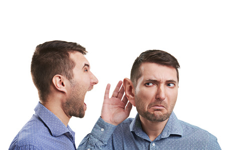 young businessman with big ear listening angry screaming man. isolated on white backgroundの写真素材