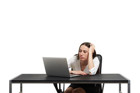 sorrowful woman looking at laptop. isolated on white backgroundの写真素材