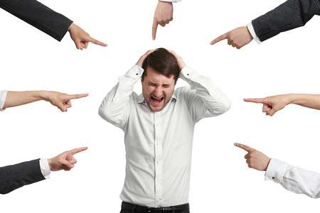 many fingers pointing at screaming stressed businessman. isolated on white backgroundの写真素材