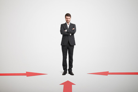 red arrows indicate at pensive businessman in formal wear over light grey backgroundの写真素材