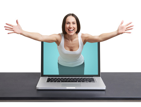 laughing woman come out from laptop and stretching out her hands against white backgroundの写真素材