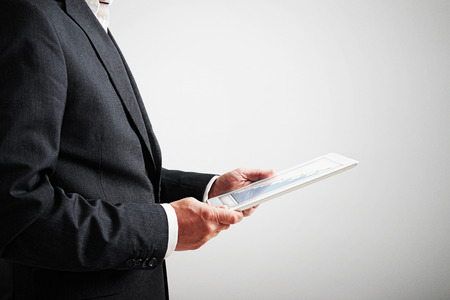 close up picture of businessman holding tablet pc with bar graphicの写真素材
