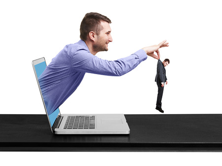 Smiley man got out of the computer and keeping the small sad man over white の写真素材
