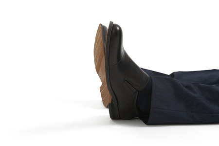 close up of lying mans legs in black shoes. isolated on white backgroundの写真素材