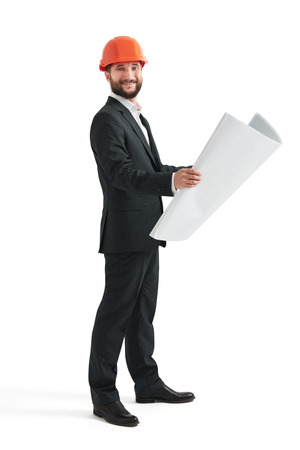 smiley businessman in orange hardhat with blueprint looking at camera. isolated on white backgroundの写真素材