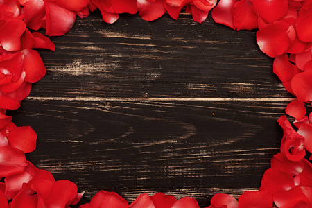 beautiful frame with red rose petals on wooden vintage backgroundの写真素材