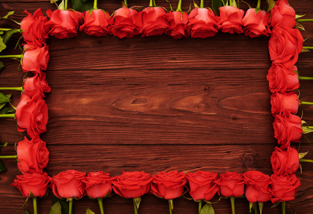 frame from red roses with empty wooden copyspaceの写真素材