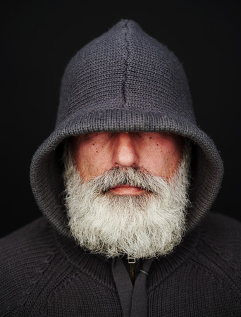 bearded senior man under the hood over black background