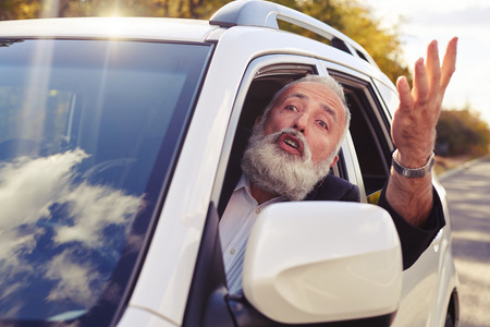 discontented man shouting from the window of his car