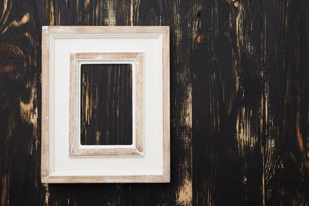 Vintage white empty frame on dark wooden wallの写真素材