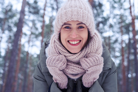 Low angle of woman face with blue eyes and perfect make-up isolated in the wintry forest. A walk in...