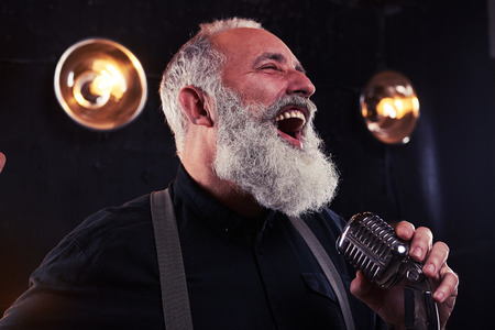 Close-up of positive engaging man performing solo and posing at the camera.の写真素材