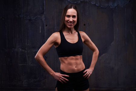 Close-up of happy and healthy woman with hands on hips posing against background.の写真素材