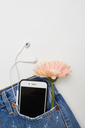 Top view shot of modern ripped denim shorts with headphones and phone lying in the pocketの写真素材
