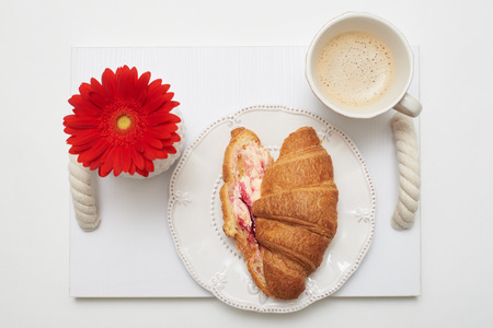 Flat lay picture of light morning breakfast on service tray. Coffee and croissant isolated on white backgroundの写真素材