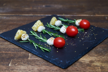 Close-up of skewers made of rosemary with cheese and tomatoesの写真素材