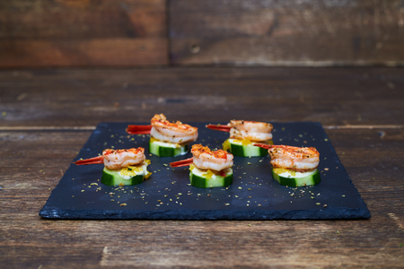 Mid shot of marinated shrimps on grilled zucchinis with white sauceの写真素材