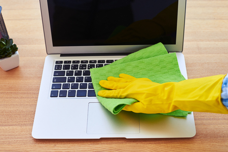 Cropped shot of charwoman cleaning with dry mop laptopの写真素材