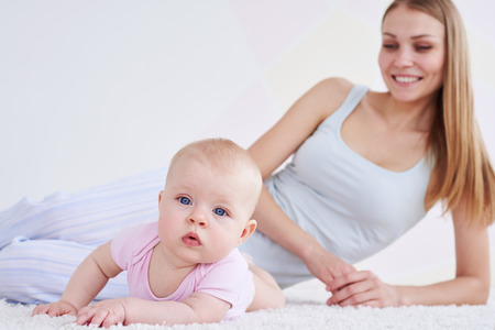 Mum and a girl lying on a carpetの写真素材