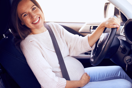 Closeup of positive woman posing at camera in carの写真素材