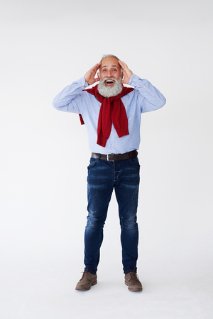 Full-length shot of mature surprised bearded man holding head with handsの写真素材