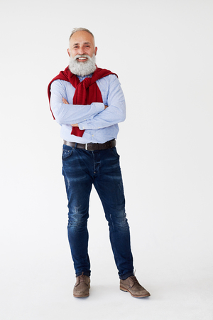 Full-length shot of casual pleased man posing with arms folded, isolated on white backgroundの写真素材