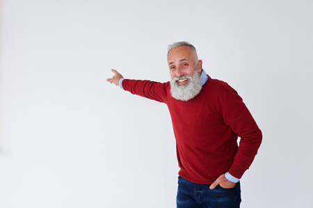Closeup of smiling senior bearded man pointing backwards at copy spaceの写真素材