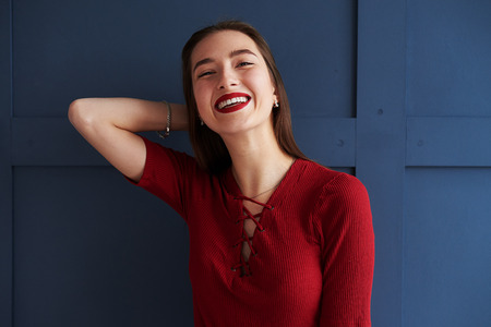 Portrait of beautiful girl with red lips posing over backgroundの写真素材