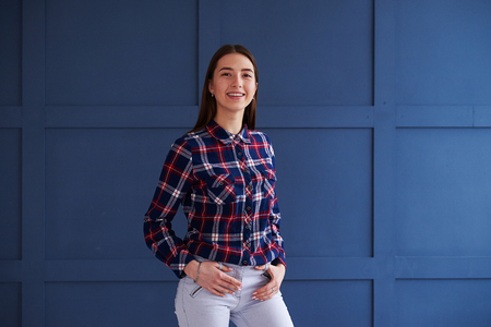 Closeup of cheerful girl holding hands on pockets posing at camera の写真素材