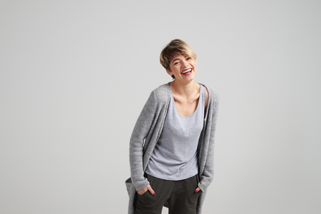 Closeup of happy laughing young woman with short hair posing at cameraの写真素材