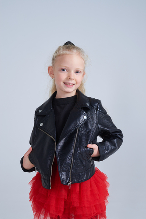 Closeup shot of smiling blonde girl wearing leather jacket posing isolatedの写真素材