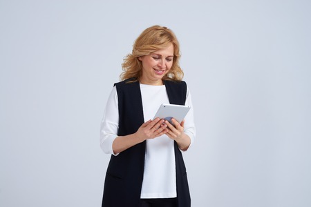 Smiley mature woman using tablet pcの写真素材