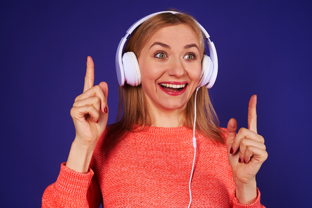blond in headphones listening something interestingの写真素材