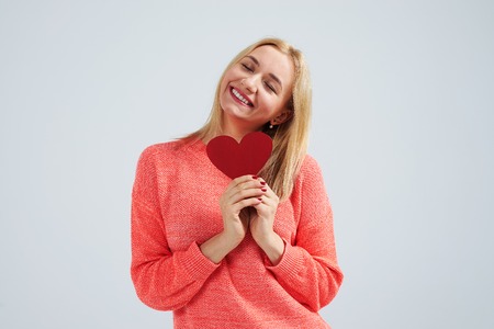 smiley blond with small red heartの写真素材