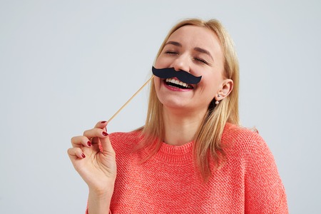laughing blond with fake moustacheの写真素材