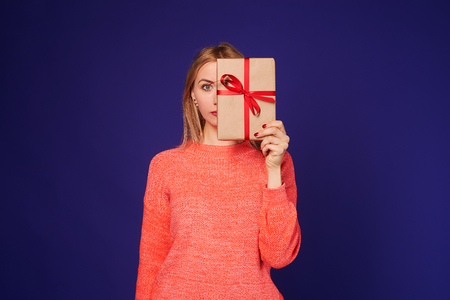 blond hiding face behind gift boxの写真素材