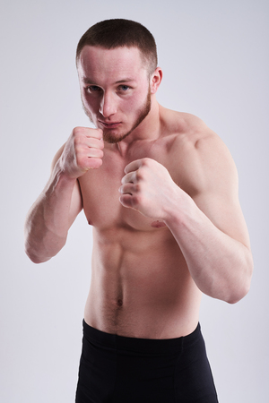 young boxer with naked torso posing in studioの写真素材