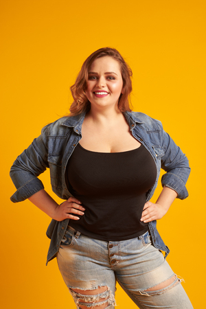 Beautiful plus-size model with big breast smiling at cameraの写真素材