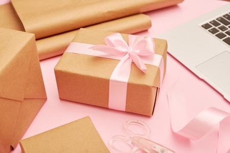 Cute present box with laptop placing on pink flatlayの写真素材